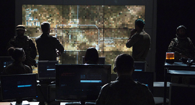 Group of military people in dark room watching the monitor