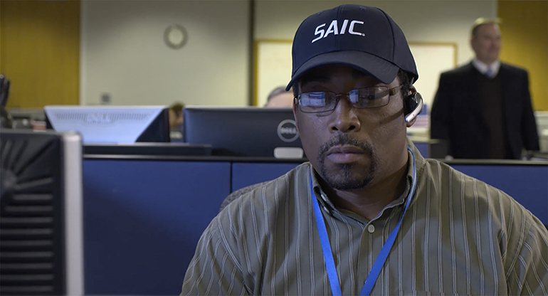 An SAIC employee talking on a headset, supporting customers