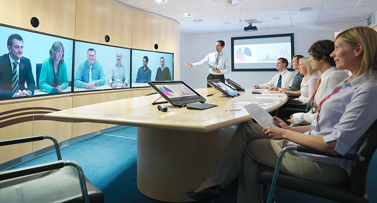 Business people in meeting room taking part in video conference