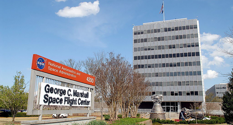 The George C. Marshall Flight Center building, seen from the front. The sign is on the left and the building is on the right. 